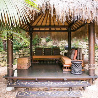 Idee per un grande patio o portico etnico dietro casa con pavimentazioni in pietra naturale e una pergola