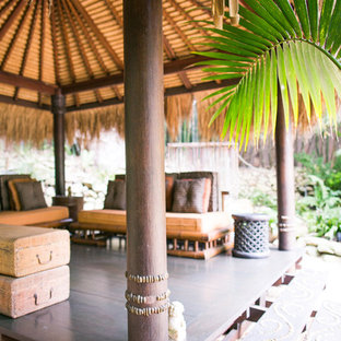 Idee per un grande patio o portico etnico dietro casa con pavimentazioni in pietra naturale e una pergola