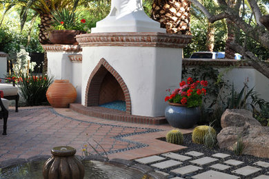 Example of a mid-sized tuscan courtyard tile patio design in Phoenix with a fire pit and no cover