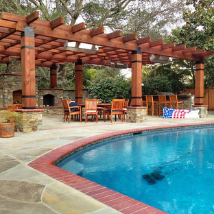 Foto di un grande patio o portico mediterraneo dietro casa con pavimentazioni in pietra naturale e una pergola
