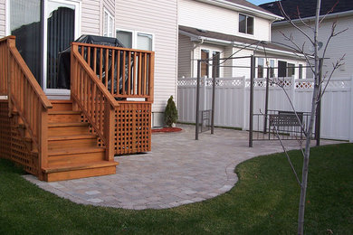 Inspiration for a mid-sized timeless backyard stone patio remodel in Toronto with no cover