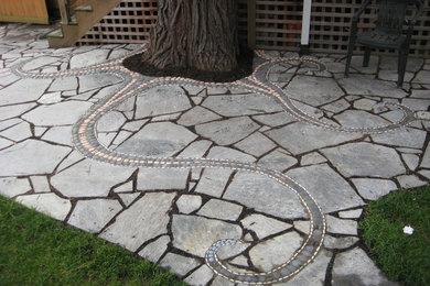 Mid-sized eclectic backyard stone patio photo in Seattle with no cover