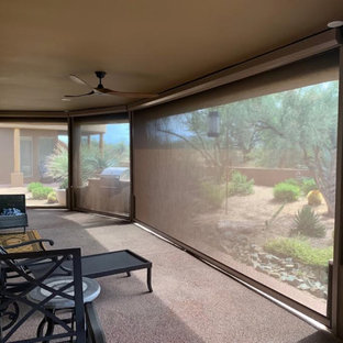 Immagine di un grande patio o portico stile americano dietro casa con pavimentazioni in cemento e un tetto a sbalzo