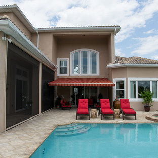 Immagine di un patio o portico contemporaneo dietro casa con un parasole