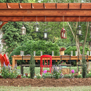 Esempio di un patio o portico country di medie dimensioni e dietro casa con una pergola