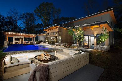Huge trendy backyard concrete patio photo in Other with a fire pit and a pergola