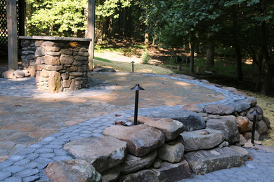 Example of a mid-sized mountain style backyard concrete paver patio design in DC Metro with a fire pit and no cover