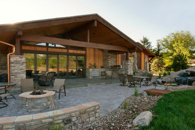 Imagen de patio de estilo americano en patio trasero y anexo de casas con cocina exterior y adoquines de piedra natural
