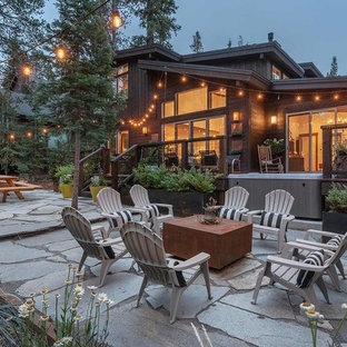 Immagine di un grande patio o portico rustico dietro casa con un giardino in vaso e nessuna copertura