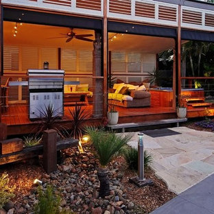 Immagine di un grande patio o portico tradizionale dietro casa con cemento stampato e un tetto a sbalzo