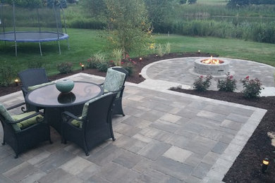 Modern back patio in Chicago with brick paving and no cover.