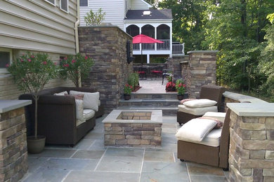 Example of a large transitional backyard stone patio design in DC Metro with a fire pit and no cover