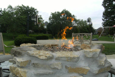Example of a mid-sized classic backyard patio design in Indianapolis with a fire pit and no cover