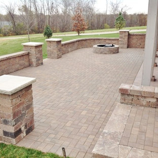Foto di un grande patio o portico classico dietro casa con un focolare e pavimentazioni in mattoni