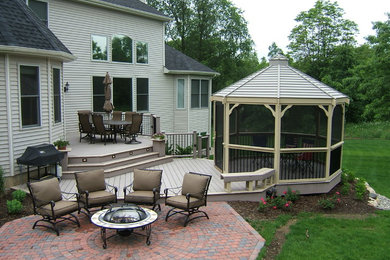 Imagen de patio clásico renovado grande sin cubierta en patio trasero con brasero y adoquines de ladrillo