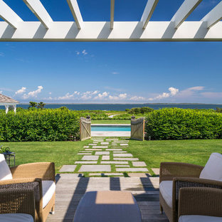 Foto di un ampio patio o portico costiero dietro casa con pedane e una pergola