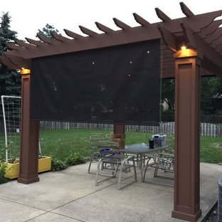 Esempio di un patio o portico classico di medie dimensioni e dietro casa con lastre di cemento e una pergola