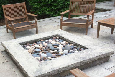 Foto de patio actual de tamaño medio sin cubierta en patio trasero con brasero y adoquines de piedra natural