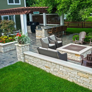 Ispirazione per un grande patio o portico classico dietro casa con un focolare, pavimentazioni in cemento e una pergola