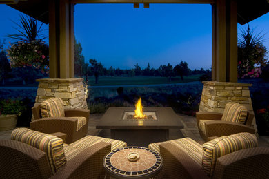 Inspiration for a mid-sized southwestern backyard stone patio remodel in Toronto with a fire pit and a roof extension