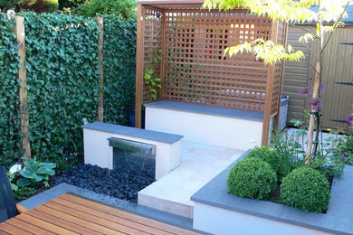 Cette image montre une petite terrasse arrière design avec des pavés en pierre naturelle.
