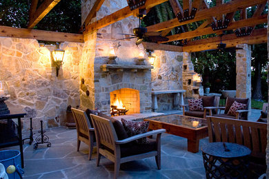 タンパにある広いカントリー風のおしゃれな裏庭のテラス (屋外暖炉、天然石敷き、パーゴラ) の写真