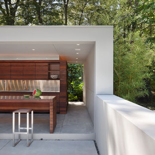 Inspiration for a large modern backyard concrete patio kitchen remodel in New York with a gazebo