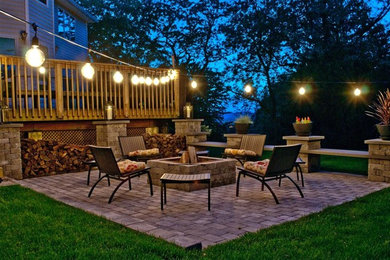 Patio - transitional backyard brick patio idea in Other with a fire pit