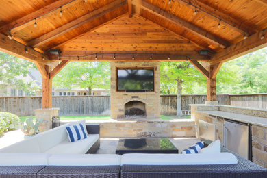 Inspiration for a large timeless backyard stone patio remodel with a fire pit and a gazebo