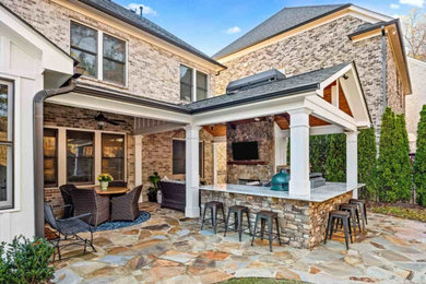 На фото: двор среднего размера на заднем дворе в классическом стиле с летней кухней, покрытием из каменной брусчатки и навесом с