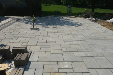 Large minimalist backyard concrete paver patio photo in Other