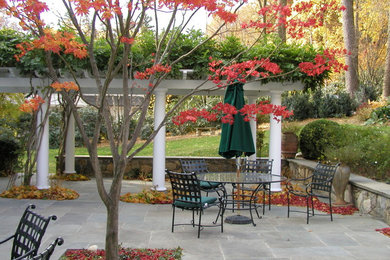 Imagen de patio clásico grande sin cubierta en patio trasero con fuente