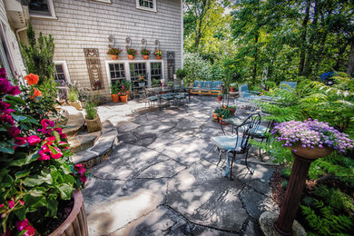 Design ideas for a large traditional back patio in New York with natural stone paving and no cover.