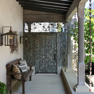 Esempio di un patio o portico etnico di medie dimensioni e dietro casa con lastre di cemento e un tetto a sbalzo