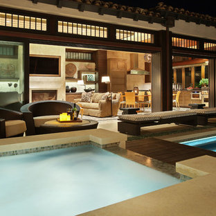 Immagine di un ampio patio o portico etnico dietro casa con piastrelle, nessuna copertura e con illuminazione