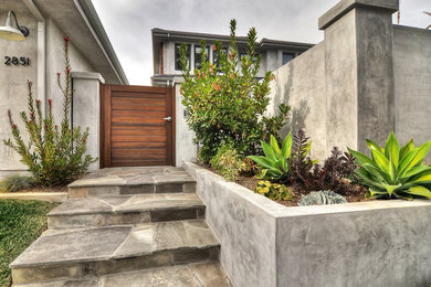 Example of a mid-sized minimalist front yard stone patio container garden design in Orange County with no cover