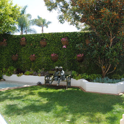 Large elegant backyard concrete paver patio vertical garden photo in Orange County with a roof extension
