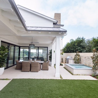 Foto di un patio o portico costiero di medie dimensioni e dietro casa con fontane, piastrelle e un tetto a sbalzo