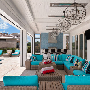 Foto di un ampio patio o portico contemporaneo dietro casa con pavimentazioni in pietra naturale e un tetto a sbalzo