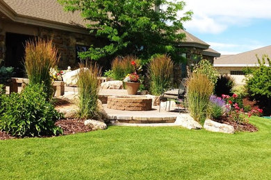 Patio - large traditional backyard stone patio idea in Boise with a fire pit and a roof extension