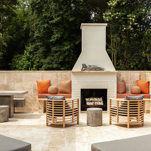 Foto di un grande patio o portico classico dietro casa con nessuna copertura, piastrelle e un caminetto