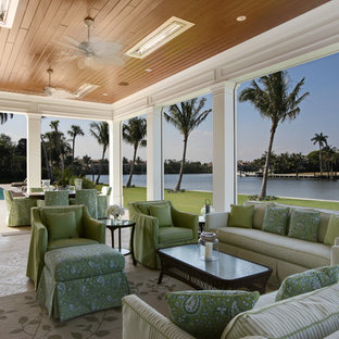 Idee per un ampio patio o portico stile marino dietro casa con piastrelle e una pergola