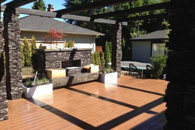 Foto de patio clásico renovado de tamaño medio en patio trasero con cocina exterior, entablado y pérgola