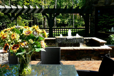 Inspiration for a mid-sized transitional backyard brick patio fountain remodel in Cleveland with no cover