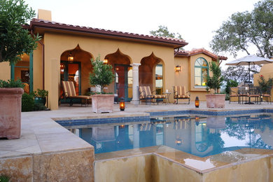 Ejemplo de patio mediterráneo grande en patio trasero y anexo de casas con cocina exterior y adoquines de piedra natural