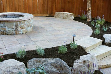 Ejemplo de patio clásico de tamaño medio sin cubierta en patio trasero con brasero y adoquines de piedra natural