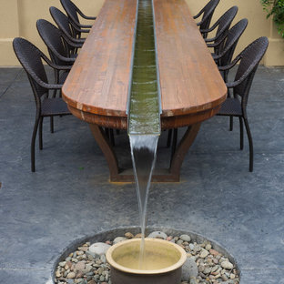 Medium sized traditional back patio in Other with a water feature, stamped concrete and a pergola.