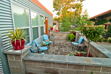 Example of an eclectic side yard concrete paver patio design in Boise