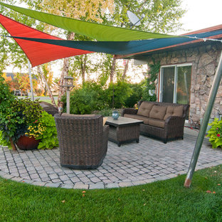 Esempio di un patio o portico boho chic dietro casa con un giardino in vaso, pavimentazioni in cemento e un parasole