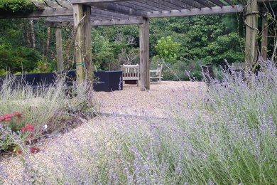 Inspiration for a huge contemporary backyard gravel patio remodel in New York with a fire pit and a pergola